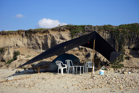 White plastic chairs under black tent on the and beach, Israelの写真素材