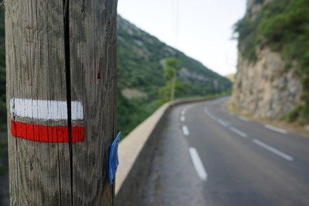 Post with red and white sign on the road