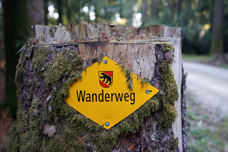 MURTEN, SWITZERLAND - CIRCA AUGUST 2015 Stub with yellow sign Wanderweg on the hiking trail ib the Swiss forestの写真素材