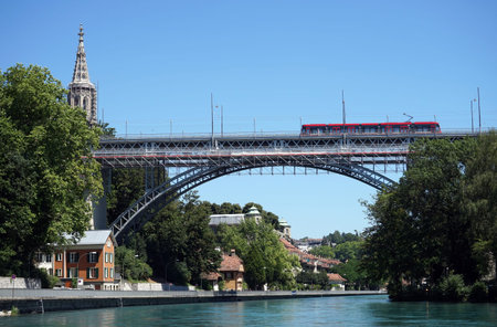 BERN, SWITZERLAND - CIRCA AUGUST 2015Red tram on the bridge on the Aare river