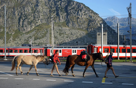 ANDERMATT, SWITZERLAND - CIRCA AUGUST 2015 Women with horses near railway stationのeditorial素材