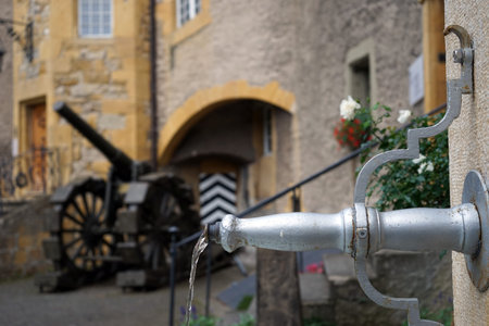 MURTEN, SWITZERLAND - CIRCA AUGUST 2015 Fountain and old gun in the inner yard of castle
