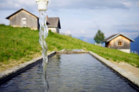 Spring with clean water near farm houses in Lichtensteinの写真素材