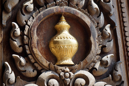 Wooden door of temple with golden vaseの写真素材