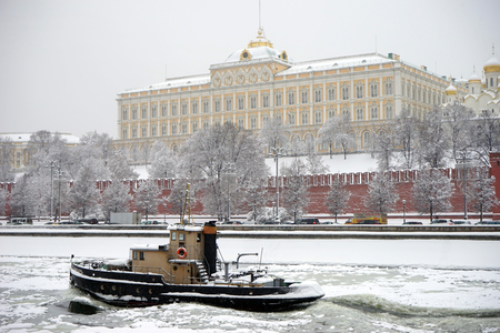 MOSCOW, RUSSIA - CIRCA FEBRUARY 2018 Wall of Kremlin with snow and Moscow river with boatのeditorial素材