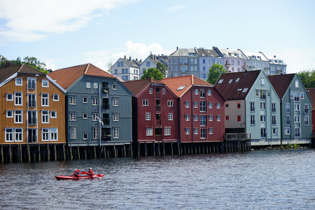 TRONDHEIM, NORWAY - CIRCA JULY 2019 Old warehouses on the river and cayakのeditorial素材