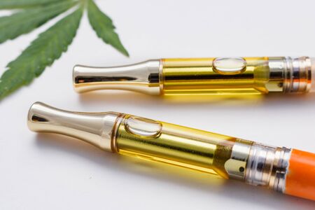Two Vape Pen THC/CBD Oil Vape Pen Cartridges & Cannabis Leafの写真素材