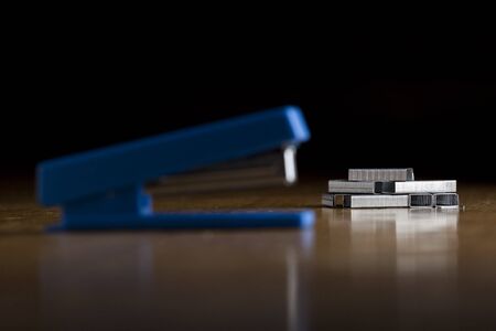 Stapler lies on a table,  black backgroundの写真素材