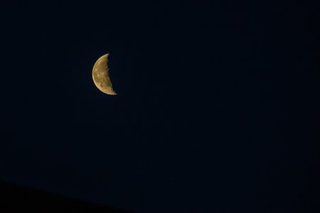 Bright half Moon on night skyの写真素材