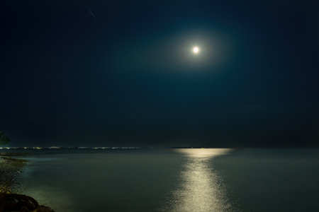 night seascape with full moon and moonlight on dark skyの写真素材