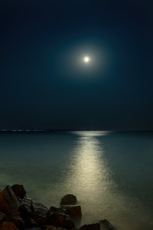 night seascape with full moon and moonlight on dark skyの写真素材