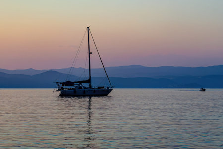 Yacht in harbor at Mediterranean sea. Sunset in Greece with mountains