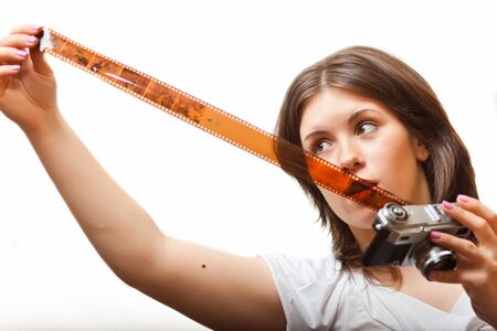 young woman looking at photofilm tape. on white backgroundの写真素材