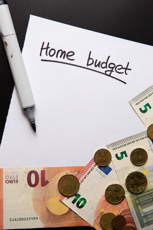 handwritten text Home Budget written and underlined on white sheet of paper, european union banknotes and coins surrounding, copyspaceの写真素材