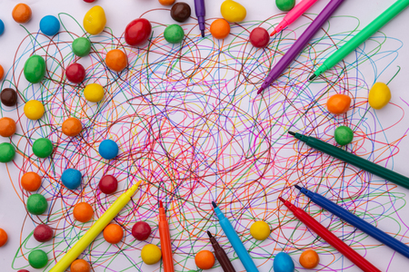 different colors felt tip pen scribble on white paper and scattered candies, abstract, creative concept, children drawingの写真素材