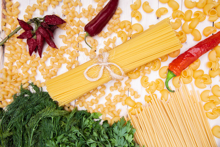 variety of italian pasta, Spaghetti, pipe rigate, cavatappi, herbs, garlic, pepper and tomatoes forming frameの写真素材