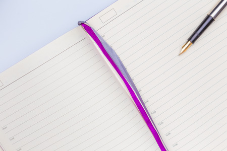 Empty diary or notepad and fountain pen with golden nib closeup side viewの写真素材