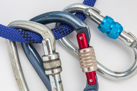 old used metal carabines in scratches on a rope for mountaineering on white background. Climbing conceptの写真素材