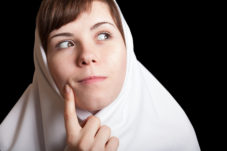 young woman funny dreaming meditating nun in white isolated on black background facial portraitの写真素材