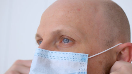 Close-up of the face of a doctor who puts on a mask and goggles before working in the infectious...
