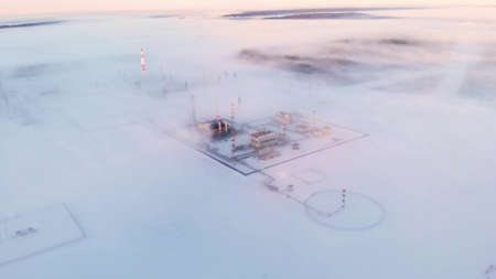 Oil and gas field in siberia in winter. Oil production in arctic conditions at extremely low temperatures. Fuel crisis in the world, rising fuel and gas prices in Europe and America. Drone view.の写真素材