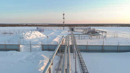 A drone flies over a pipeline, a gas pipeline at an oil and gas field in Siberia. Natural gas reserves in Russia or Canada. Rising gas prices in the world. Flight over the pipeline in winter.の写真素材
