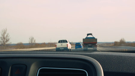 View from the front window of the car while driving. Overtaking a truck on the highway. Routine...
