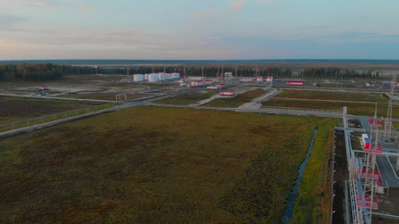 Sunrise over an oil and gas field. Drone view of oil tanks and pipelines. Oil and gas industry in...