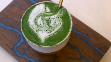 Close-up of a mug of matcha tea with green froth. A cup of hot macha with vegetable milk, an...