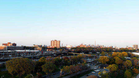 Movement from bottom to top with view of highway of fast driving cars and skyscrapers in background. Drone view of busy highway at sunset in city Enjoy fall view of city and dynamic traffic on highwayの写真素材