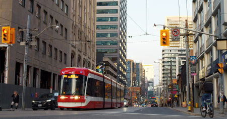 Toronto, Canada - May 6, 2023: Tram navigates city, easing traffic jam woes, providing efficient travel solution. Highlighting trams role reducing traffic jams transit alternative busy urban areas.のeditorial素材