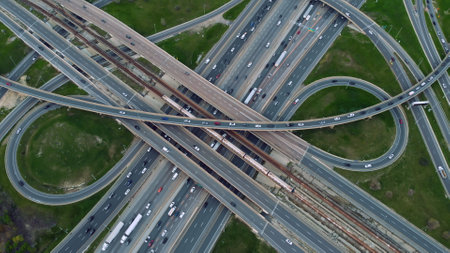 Aerial urban spectacle, metro train cuts through traffic-heavy highways, commuters in constant motion. Aerial view where metro train intersects with vehicular veins, showcasing urban flow diversityの写真素材