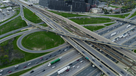Dense traffic flows on urban road network, aerial capture shows non-stop pulse of metropolitan life. Traffic weaves through city's heart, aerial perspective of endless cars on interlocking roadsの写真素材