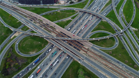 Sweeping aerial shot, busy highways interlace, seamless flow of urban traffic in motion. Sunlit...