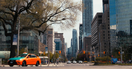 Toronto, Canada - May 6, 2023: Bustling city traffic of downtown Toronto, with taxis and cars navigating Ontario vibrant metropolis, surrounded by contemporary architecture, reflective glass facades.のeditorial素材