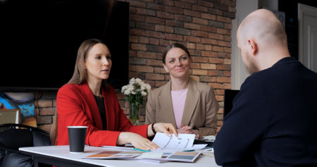 Professionals holding business meeting with clients in modern office. Discussing strategies, building relationships, consultation. Diverse group highlights collaboration, client engagement, success.の写真素材