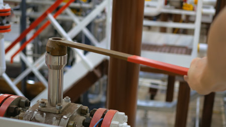 In chemical plant, worker is opening valve to resume flow of chemicals necessary for fertilizer production. Operations after scheduled maintenance, production of essential agricultural products.の写真素材
