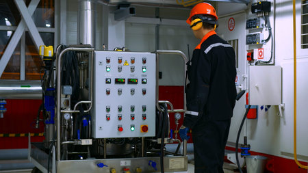 Operator adjusts parameters on control panel to ensure stable operation of industrial equipment,...