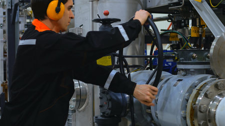 Engineer is operating large valve at industrial facility, demonstrating process. intricate process...