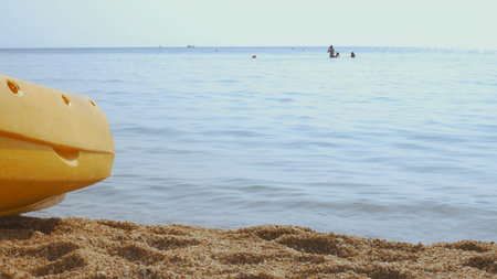 Woman in swimsuit enjoys sunny day at beach, surrounded by calm blue waters. Peaceful scene captures...