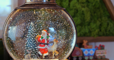Miniature winter scene inside snow globe, featuring Santa and holiday tree, brings cozy charm of fairy-tale Christmas into any space, creating magical seasonal ambiance. Christmas spirit conceptの写真素材