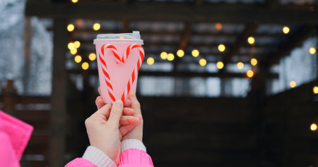 Pink takeout cup with candy cane heart raises waste awareness, since waste from single-use containers harms scenic winter vibe, urging mindful choices that reduce waste for future seasons.の写真素材