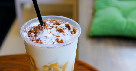 Velvety cream swirling over cold coffee, dusted with chocolate cookie crumbles, highlighting luxurious summer drink experienceの写真素材
