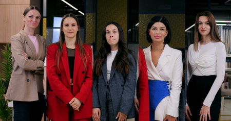 Four professional women standing confidently in office setting, confident women showcase leadership, teamwork, diversity, professional attire and poised expressions for dynamic corporate presentationの写真素材