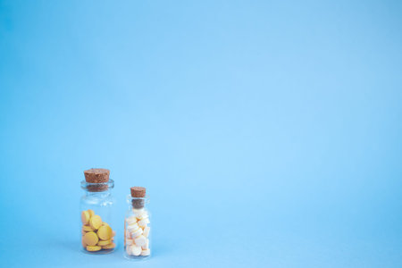 Heart made of homeopathic globules and glass bottle on pink background. Alternative Homeopathy...