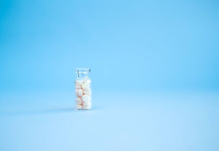 homeopathic globules and glass bottle on blue background. Alternative Homeopathy medicine herbs, healtcare and pills concept. Flatlay. Top view. copyspace for text.の写真素材