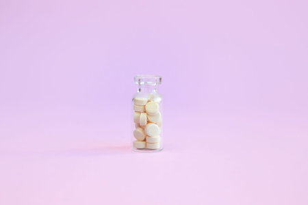 homeopathic globules and glass bottle on pink background. Alternative Homeopathy medicine herbs,...