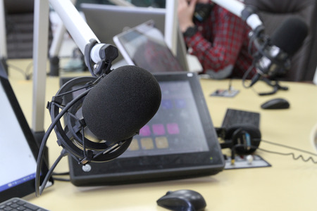 Professional audio operator working on audio mixer knobs during live TV telecastの写真素材