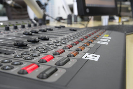 Professional audio operator working on audio mixer knobs during live TV telecast