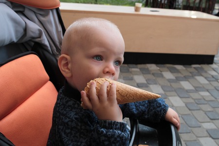 A child eats a lot of ice cream. A family at the ice cream parlor enjoying ice cream cones.の写真素材